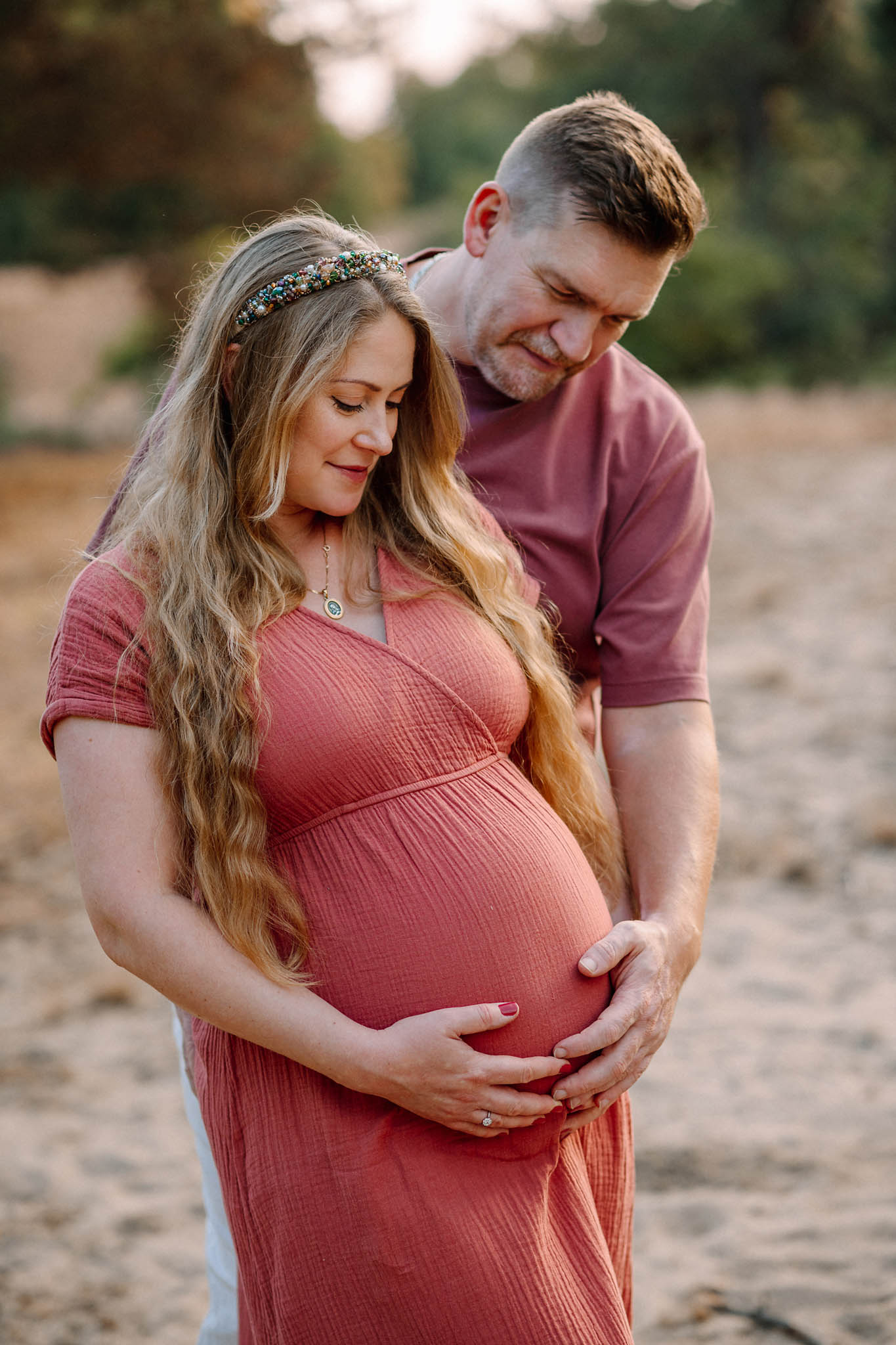 Beim Babybauch Shooting im Sonnenuntergang mit Partner