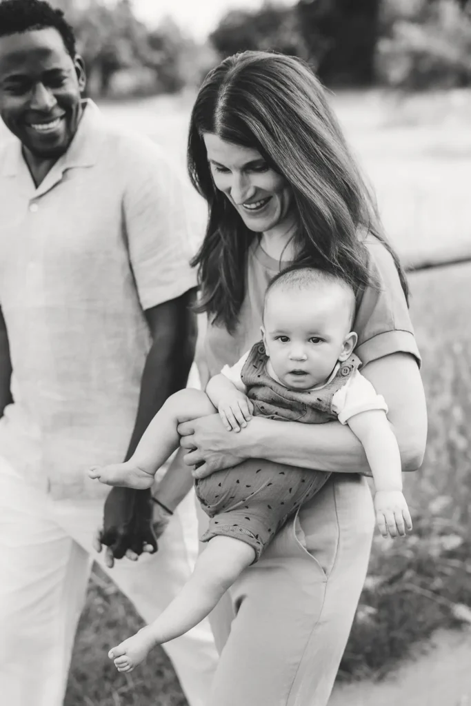 Lifestyle Familienfotografie in schwarz-weiß mit einem Baby im Arm.