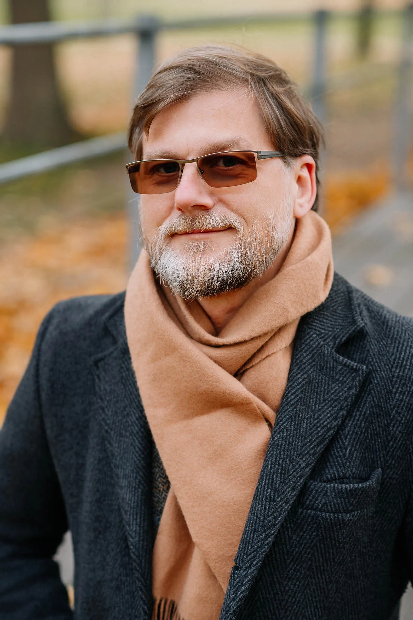 Ein herbstliches Portrait: Mann im Mantel und orangenfarbenem Schal