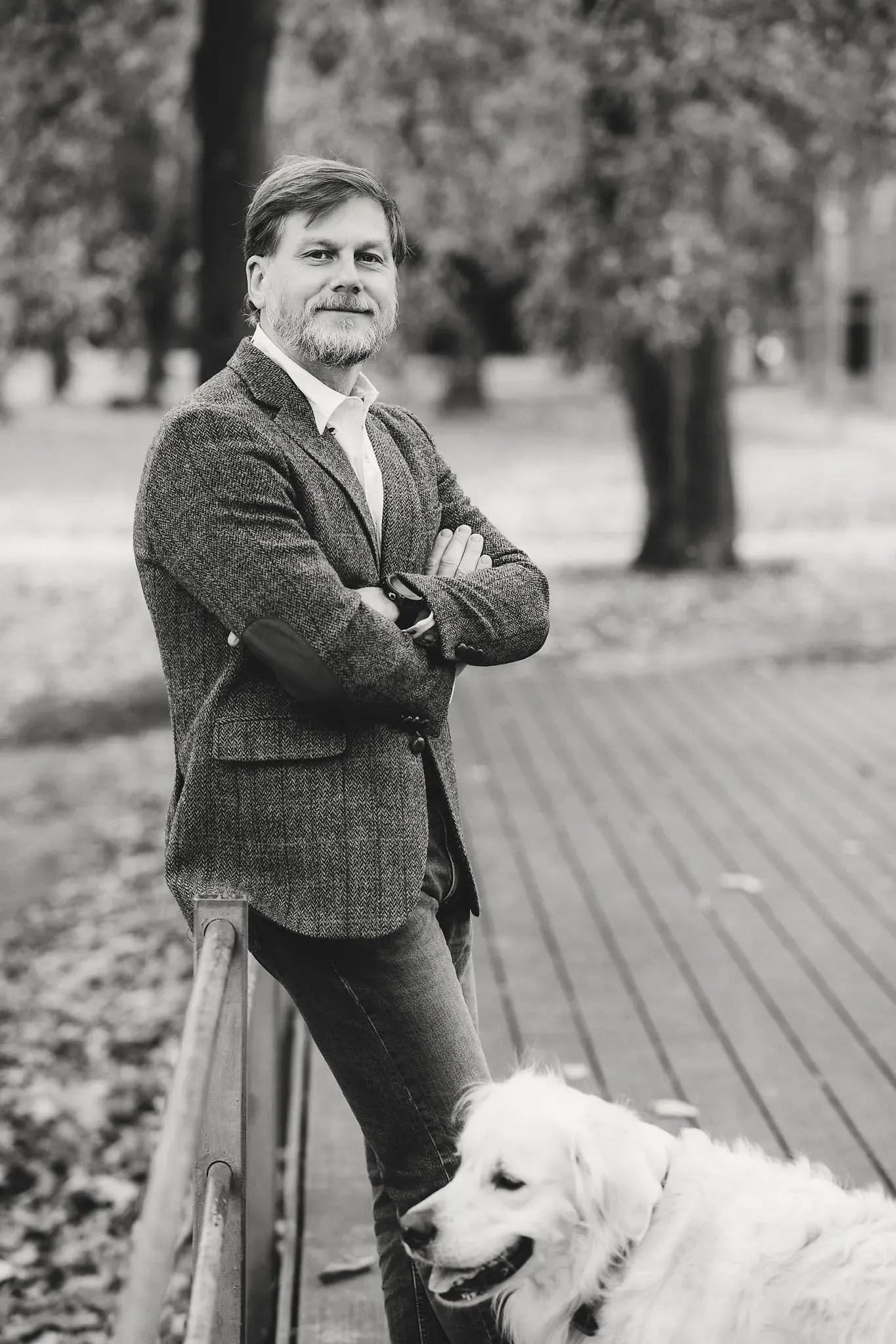 Schwarz-weiß Portraits von einem man in Sakko mit einem weißen Hund
